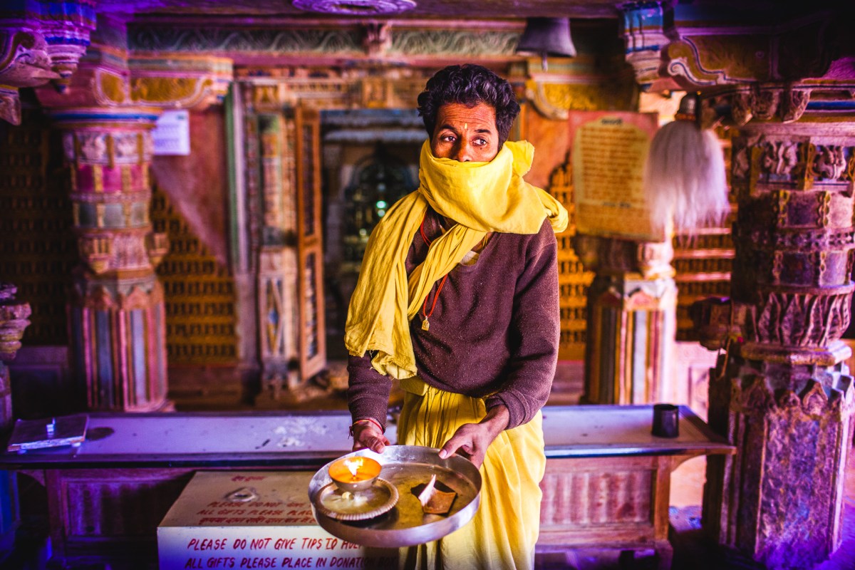 Please do not give tips. He looked at me, I looked at him, he looked at the lamp (I was meant to place my hand on top of it for a prayer), I looked at the lamp, I looked at him, he looked at me, he looked at the bill (giving a donation afterward...), I looked at the bill, he looked at me, I looked at him moving my camera upward, he initiated his eyes move on the side... I took the picture. Jaisalmer, India, 2014.