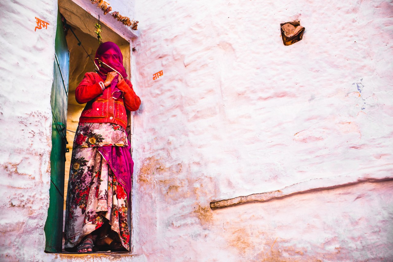 Under the veil. Of every person lies a world of memories, expectations and dreams. I'll never know what's behind the green door, I would expect a warm home for a family. Still I'll never know what her dreams are about, what life made her going through, what it is to open the green door everyday. I'll never know the world under this woman purple veil. Jaisalmer, India, 2014.