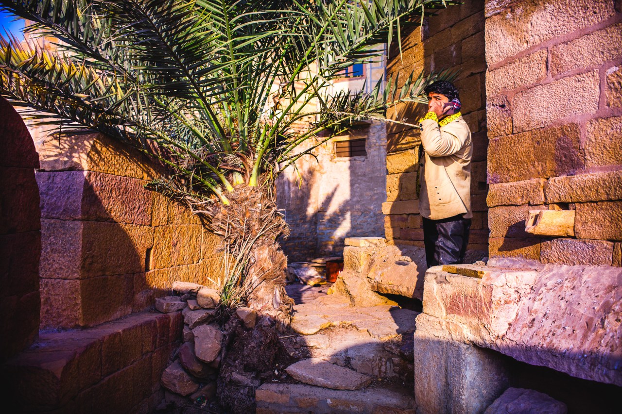 The palm tree antenna. Going around the fortifications in the early morning I find myself in front of man on the phone. He sounded quite serious, I noted the flashy yellow shirt. I don't like to disturb people when they are in a conversation, still I took a pictures quickly, then I backed off. Jaisalmer, India, 2014.